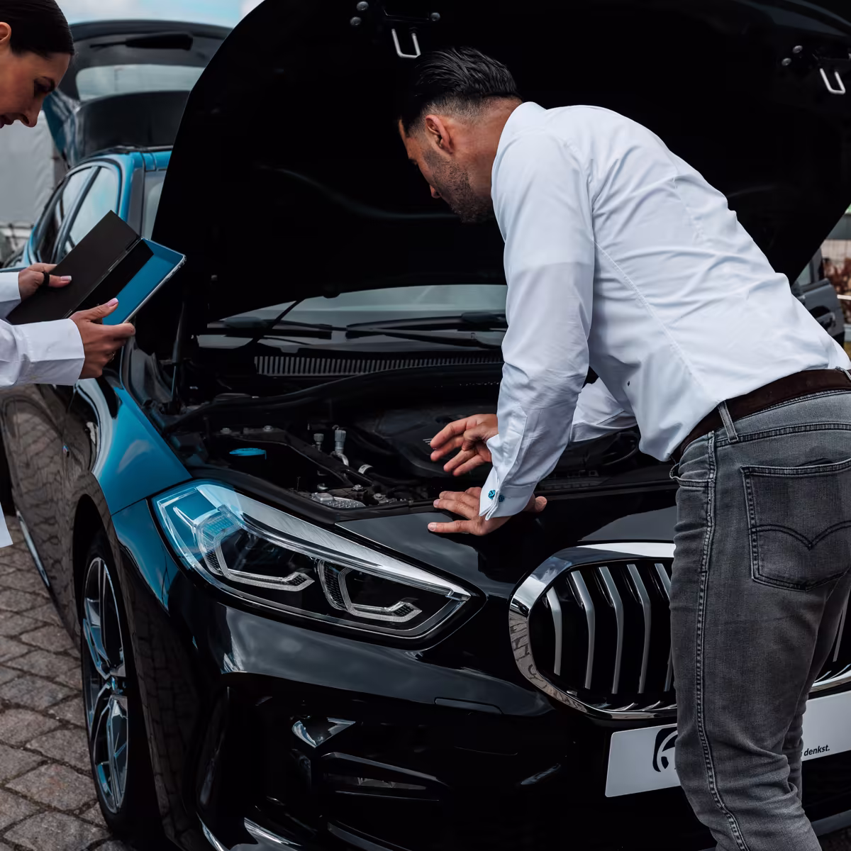 Gökhan prüft den Motorraum eines BMW